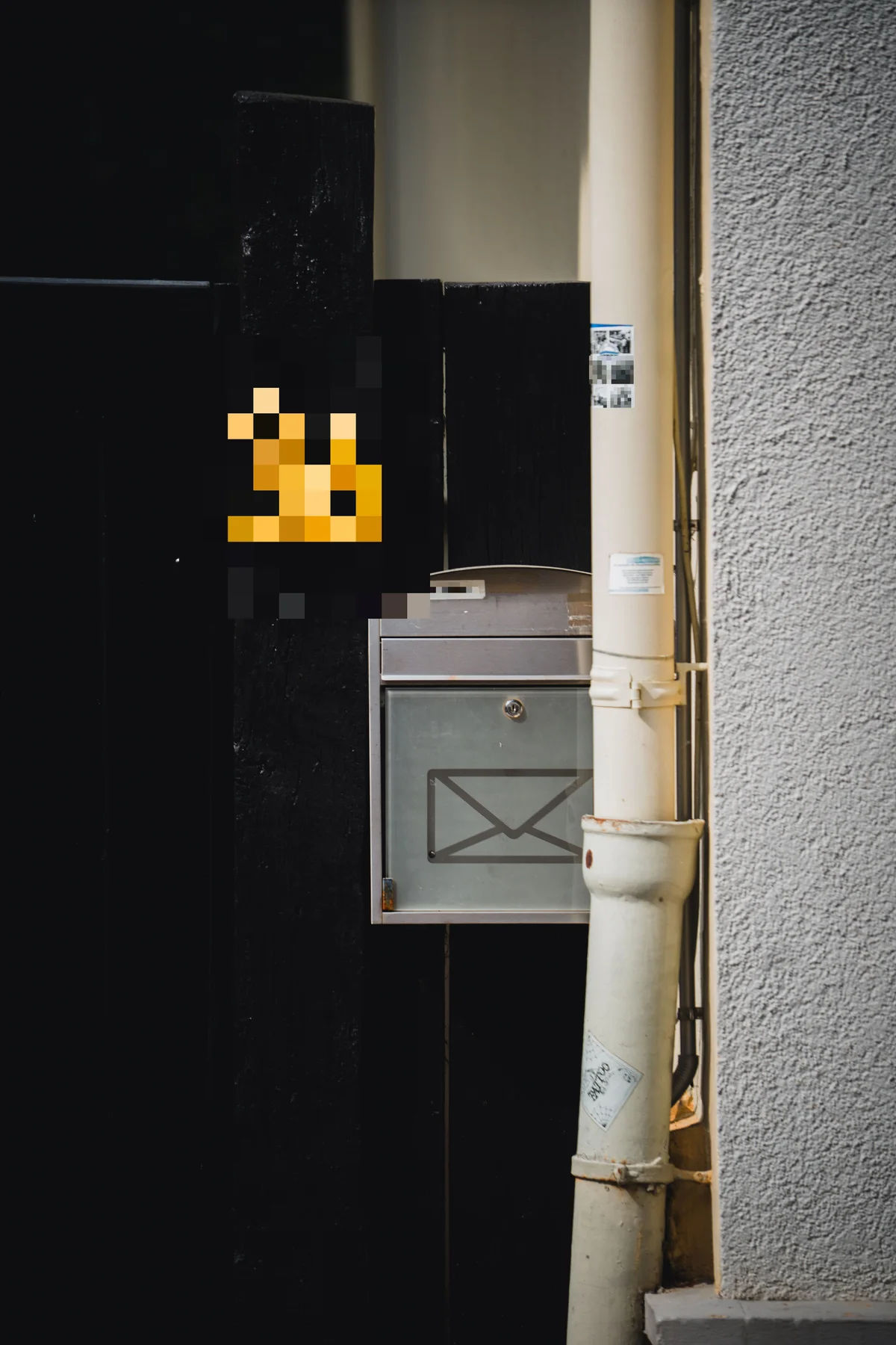 The same doorway with the house number and the mailbox nameplate pixelated into unreadable blocks