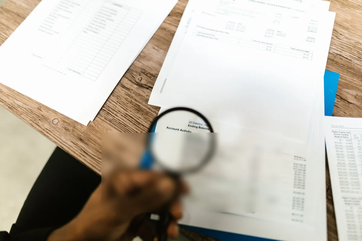 The same statement with the account activity under the magnifying glass blurred out, the rest of the desk untouched